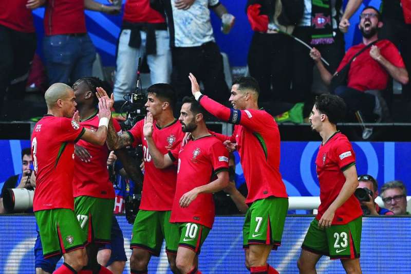 برناردو سيلفا (في الوسط) يحتفل مع زملائه بعد تسجيل الهدف الأول للبرتغال (أ ف ب)