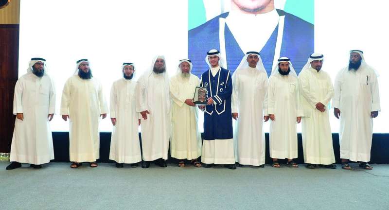 


عثمان الخميس مكرّماً أحد الطلبة الخريجين	 (تصوير سعود سالم) 