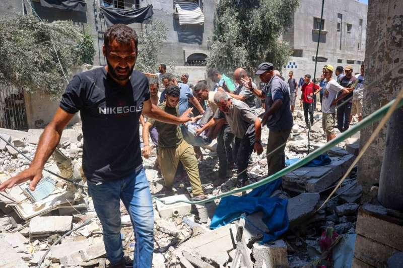 نقل شخص مصاب بين أنقاض مخيم البريج للاجئين وسط غزة (أ ف ب)