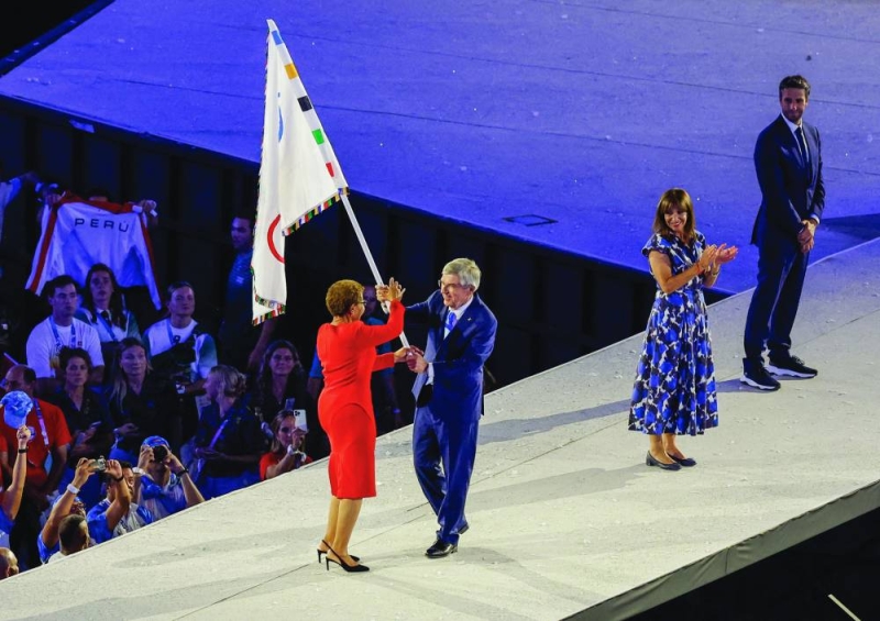 توماس باخ مسلماً العلم الأولمبي إلى عمدة لوس أنجليس كارين باس