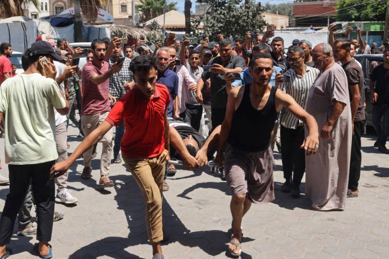 نقل أحد الجرحى لمستشفى شهداء الأقصى في ديرالبلح أمس (أ ف ب)