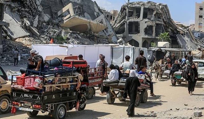 فلسطينيون يسيرون وسط الركام في غزة