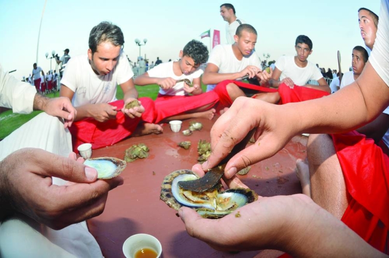 شباب الغوص يفلقون المحار لإخراج اللؤلؤ (تصوير سعود سالم)