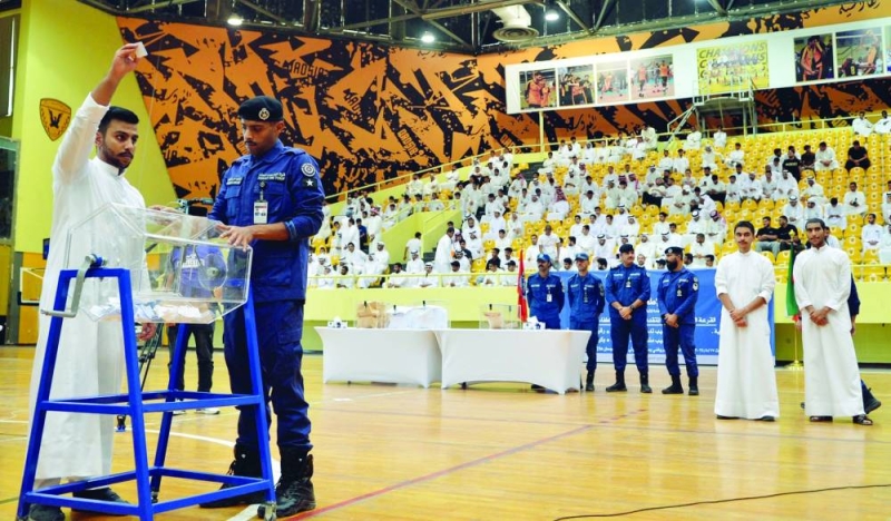 متقدّم يستعد لوضع ورقة تحمل اسمه في الصندوق قبيل إجراء القرعة
(تصوير سعود سالم)