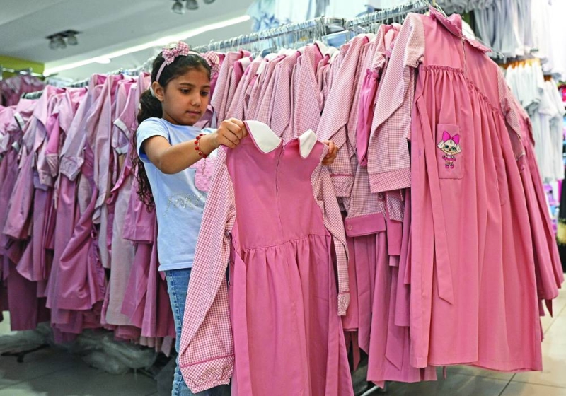 طالبة تقيس «مريولها» استعداداً للدراسة