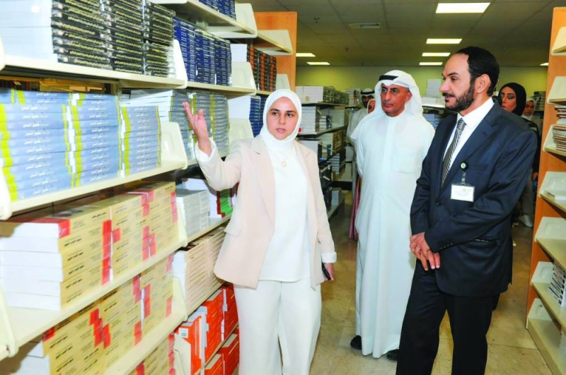 المطيري يستمع إلى شرح عن محتويات المكتبة