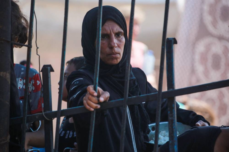 فلسطينية تنظر الحصول على طعام في خان يونس أمس (أ ف ب)