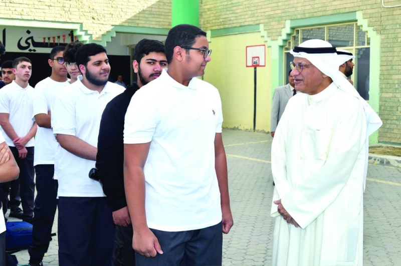 الوزير متحدثاً لأحد الطلاب في طابور الصباح