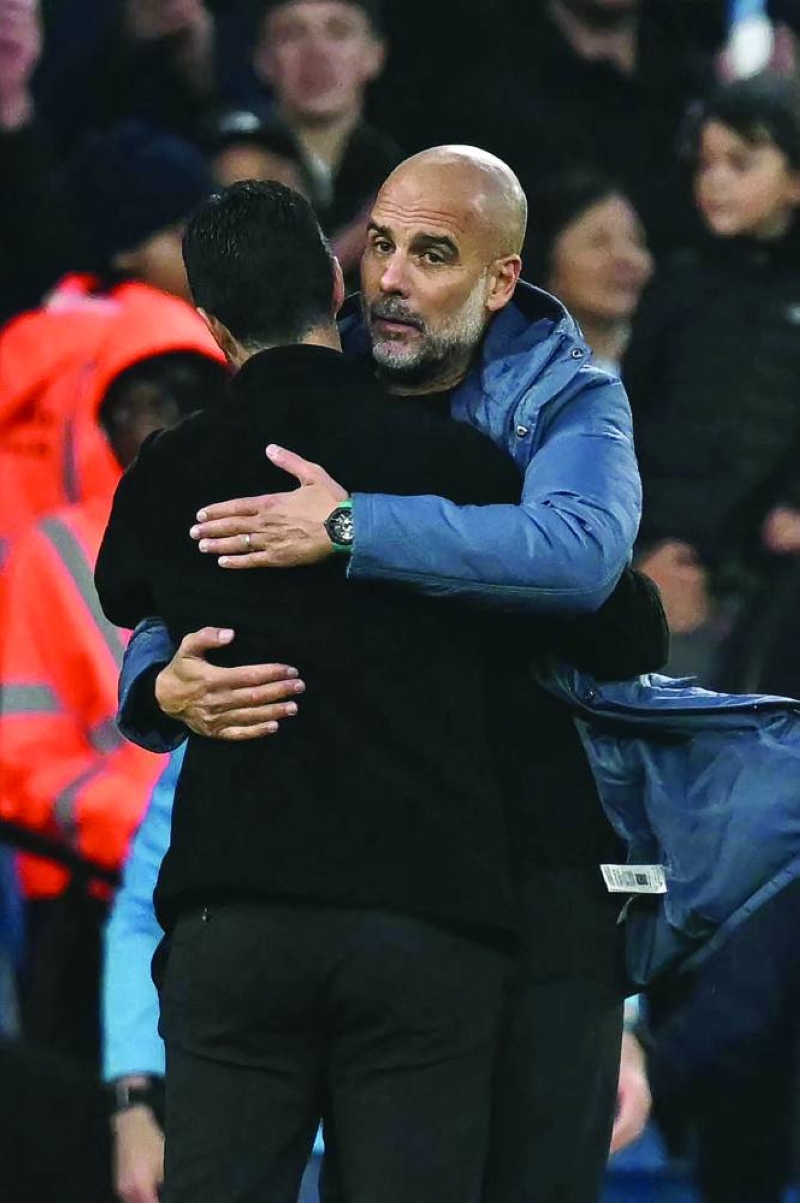 غوارديولا يحتضن مدرب أرسنال أرتيتا بعد المباراة  (أ ف ب)