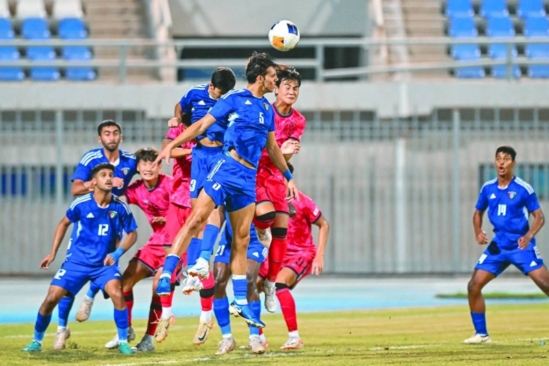 


مدافع منتخب الكويت جاسم شموه يبعد الكرة برأسه قبل اللاعب الكوري الجنوبي 
