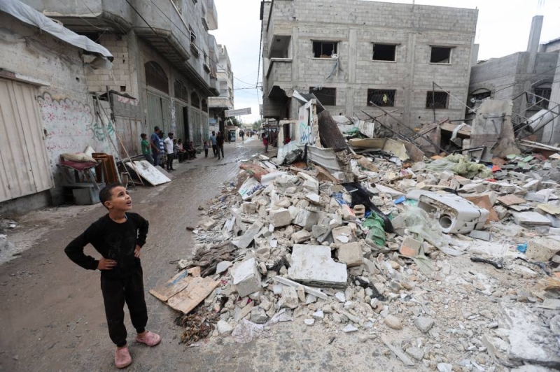 طفل ينظر إلى موقع غارة إسرائيلية على منزل في مخيم النصيرات (رويترز)
