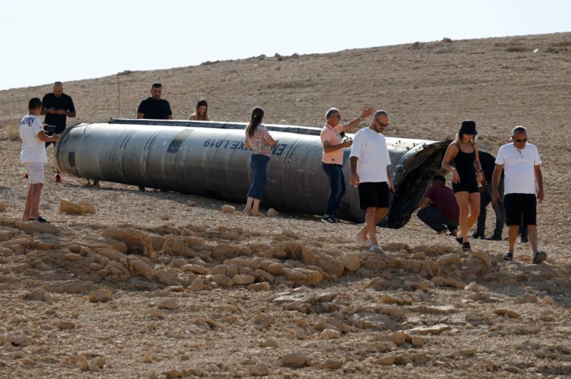 إسرائيليون يعاينون بقايا صاروخ بالستي إيراني جنوب صحراء النقب (رويترز)
 