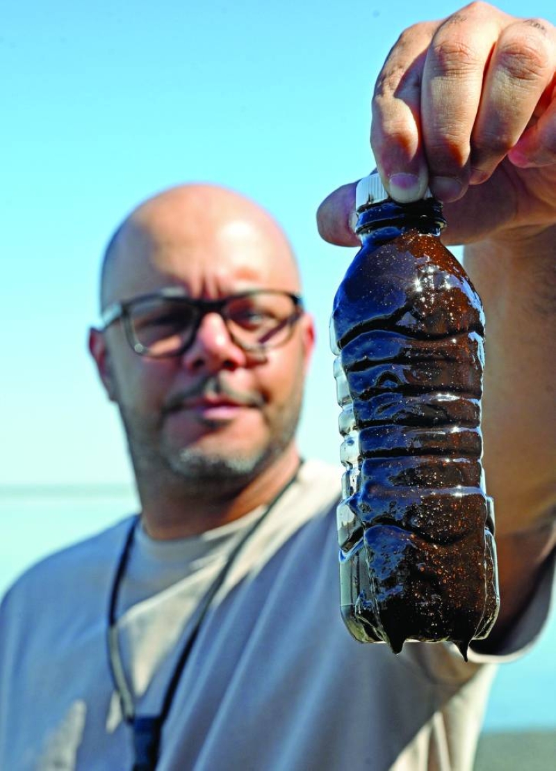 


الزيدان يحمل عينةً من الانسكابات الزيتية 