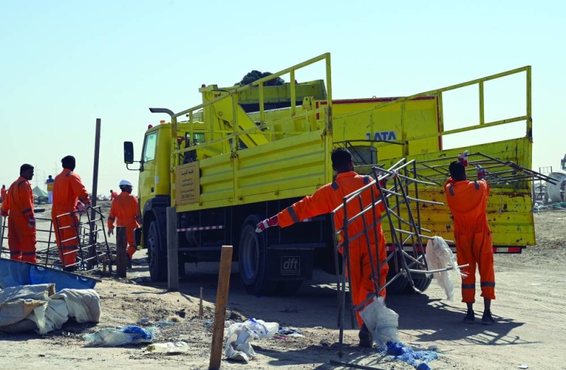عمال البلدية يضعون الأغراض المخالفة بالشاحنات