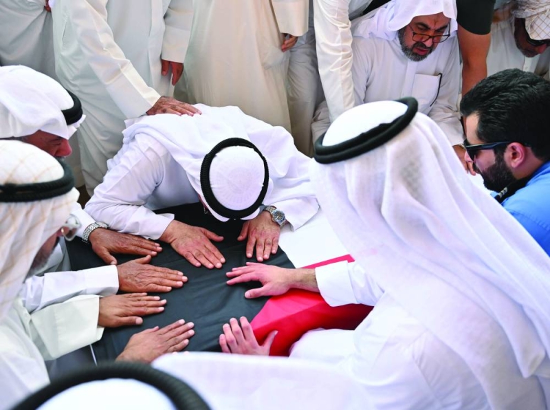 والد الشهيد يقبل نعشه 