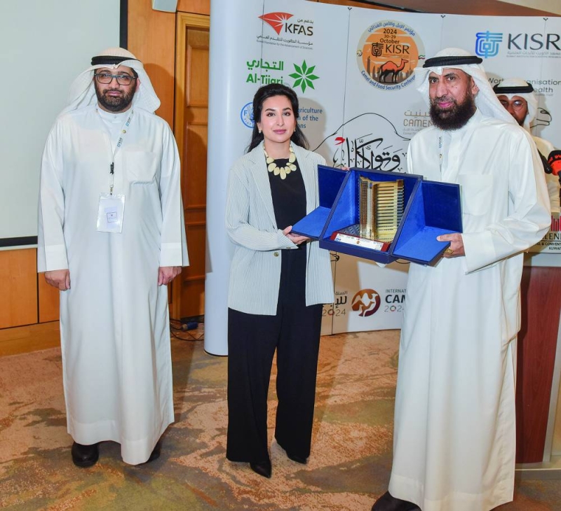 المشعان مكرماً إحدى المشاركات في مؤتمر الإبل