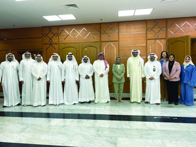 الوزيرة تتوسط مدير ومسؤولي المكتب