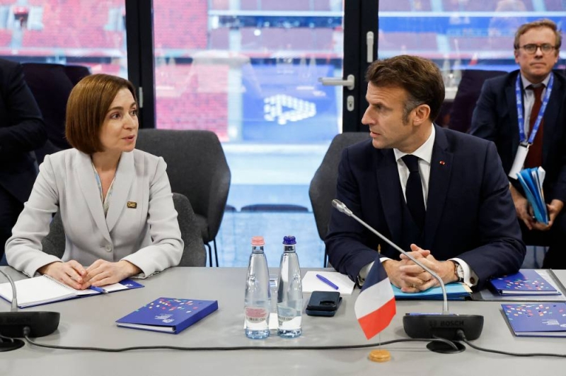 ماكرون يتحدّث إلى رئيسة مولدوفا المُنتخبة مايا ساندو خلال قمة بودابست أمس (أ ف ب) 