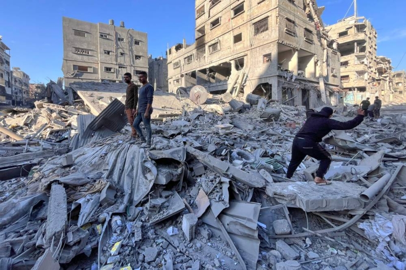 فلسطينيون يتفقدون الدمار في بيت لاهيا بعد غارات إسرائيلية (أ ف ب)