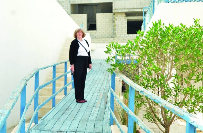 الحفيدة بيني على الممر الخشبي الموصل للطابق الثاني من بيت ديكسون (تصوير سعود سالم)