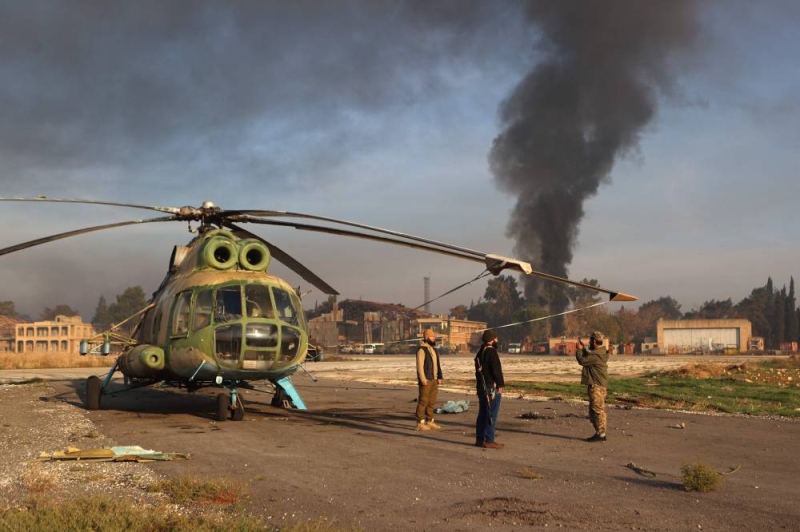 مقاتلو المعارضة قرب مروحية عسكرية على مدرج مطار النيرب العسكري في حلب 
(أ ف ب)