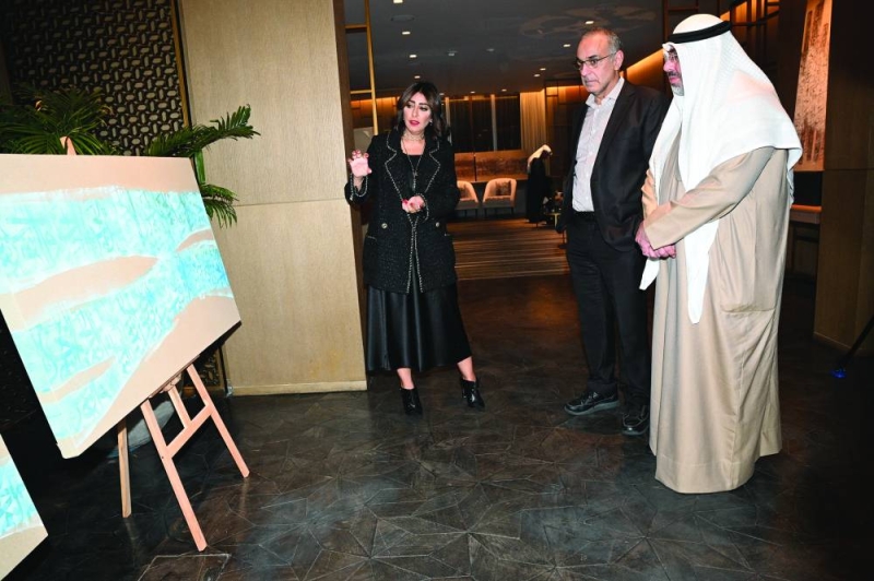 شيماء أشكناني تشرح لمحمد الجسار ومساعد الزامل عن لوحاتها (تصوير نايف العقلة)