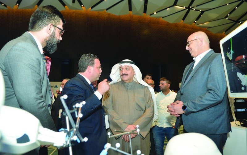 وزير الصحة مستمعاً لشرح حول عمل الروبوتات الجراحية      (تصوير سعود سالم)