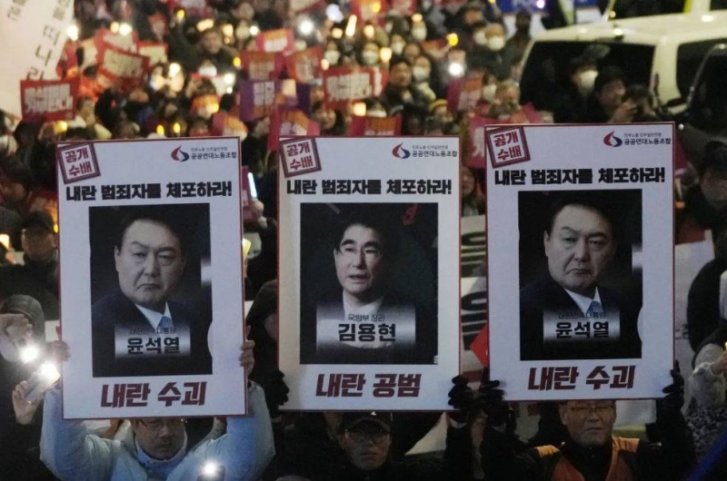 متظاهرون في سيول يحملون لافتات تطالب بإيقاف الرئيس الكوري الجنوبي ووزير دفاعه السابق 