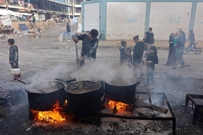 رجل يطبخ الطعام لتوزيعه في غزة (أ ف ب)
