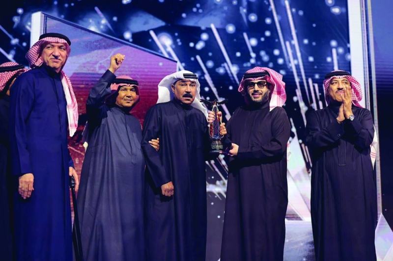 


عبدالله الرويشد محاطاً بالفنانين خلال تكريمه من آل الشيخ 