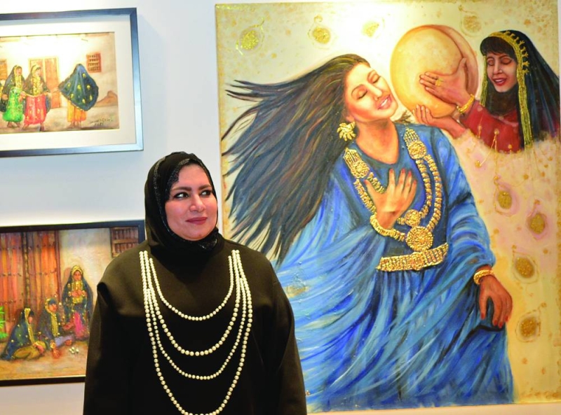 


ابتسام العصفور أمام لوحاتها	 (تصوير سعود سالم) 