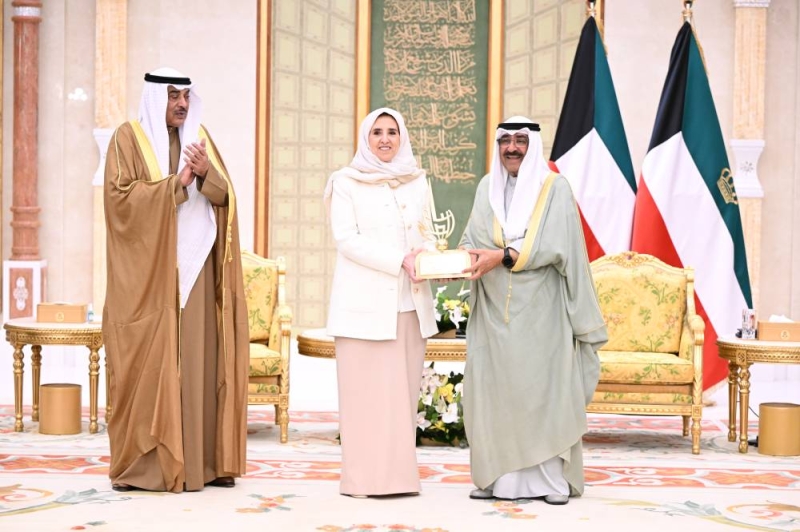 سمو الأمير متسلماً بحضور ولي العهد هدية تذكارية من عايدة سالم العلي
