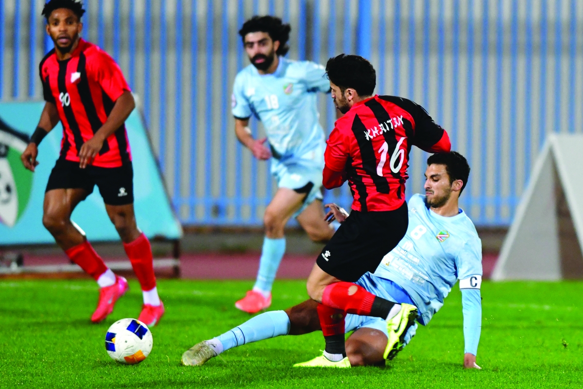 محمد الهويدي يبعد الكرة من أمام لاعب خيطان زيد زكريا