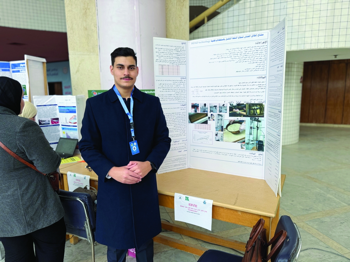 الطالب جعفر جوير أمام لوحة عرض مشروعه 