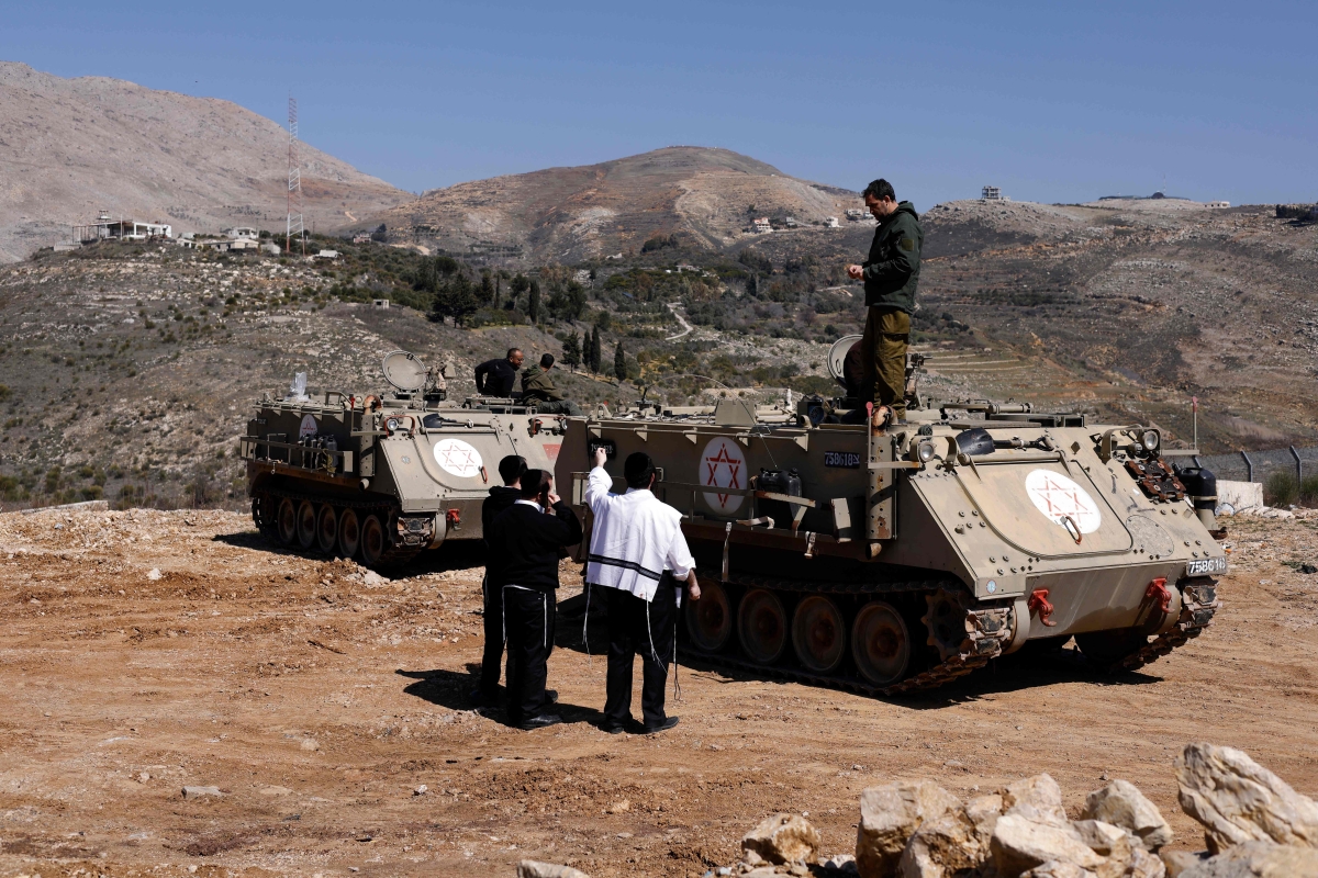 يهود متشددون يتحدثون قرب المنطقة العازلة في الجولان (أ ف ب)