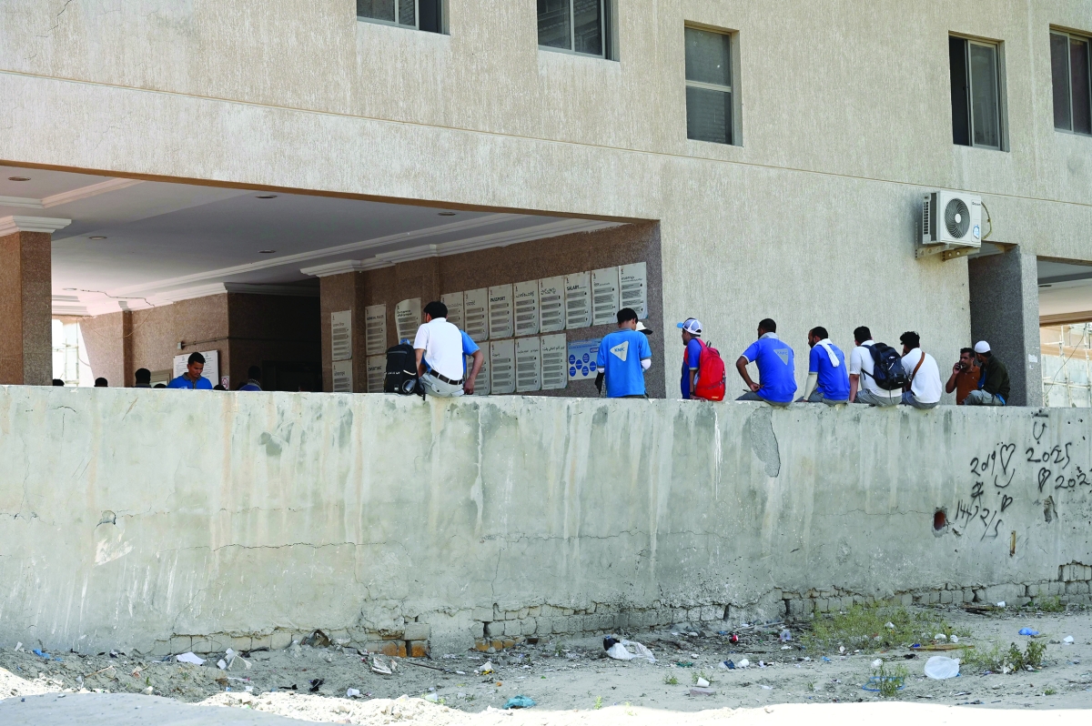 
عمال ينتظرون خارج العمارة عودة التيار	(تصوير سعود سالم) 