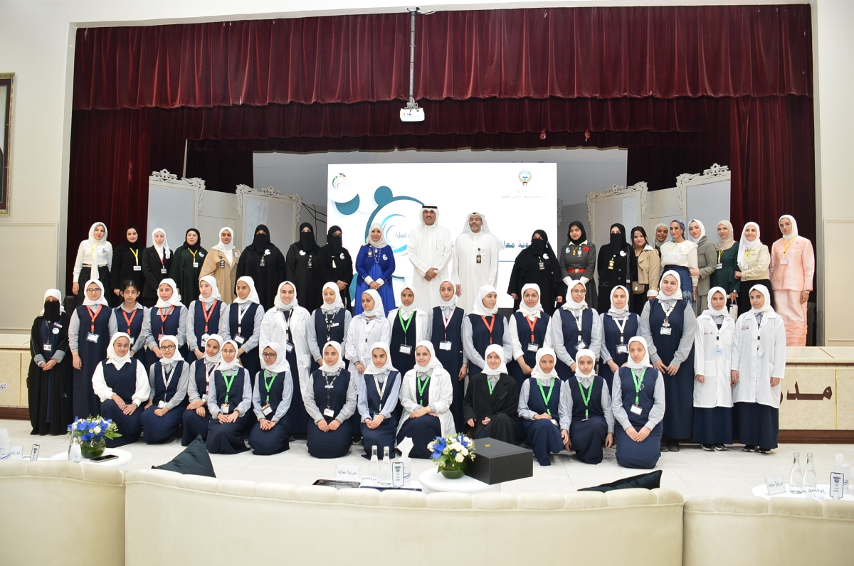 محافظ الأحمدي متوسطاً عدداً من الطالبات بحضور مسؤولي المدرسة