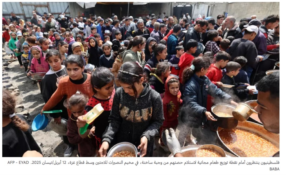 فلسطينيون ينتظرون الحصول على وجبات غذائية في مخيم النصيرات للاجئين وسط غزة  (أ ف ب)