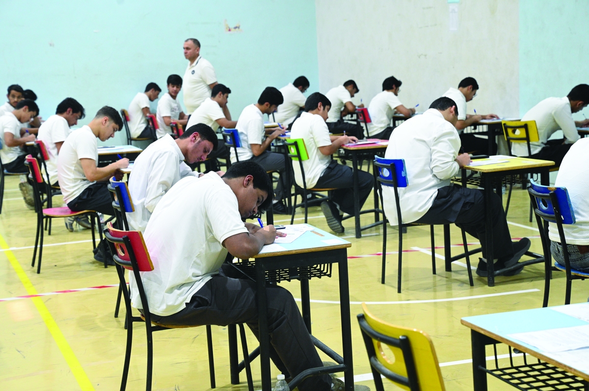 3 طلبة منهمكون في الإجابة عن الأسئلة