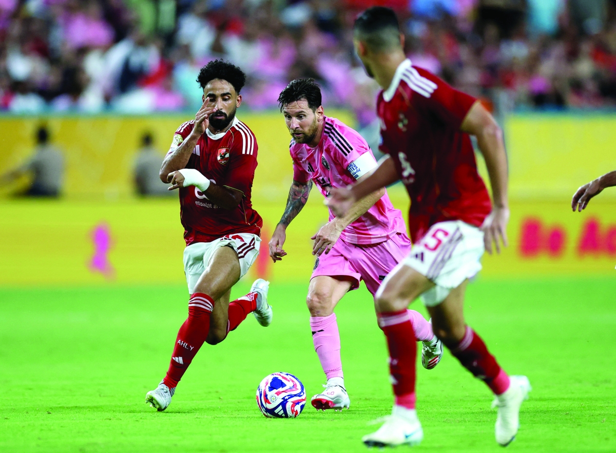 ليونيل ميسي محاولاً المرور بين لاعبي الأهلي (رويترز)