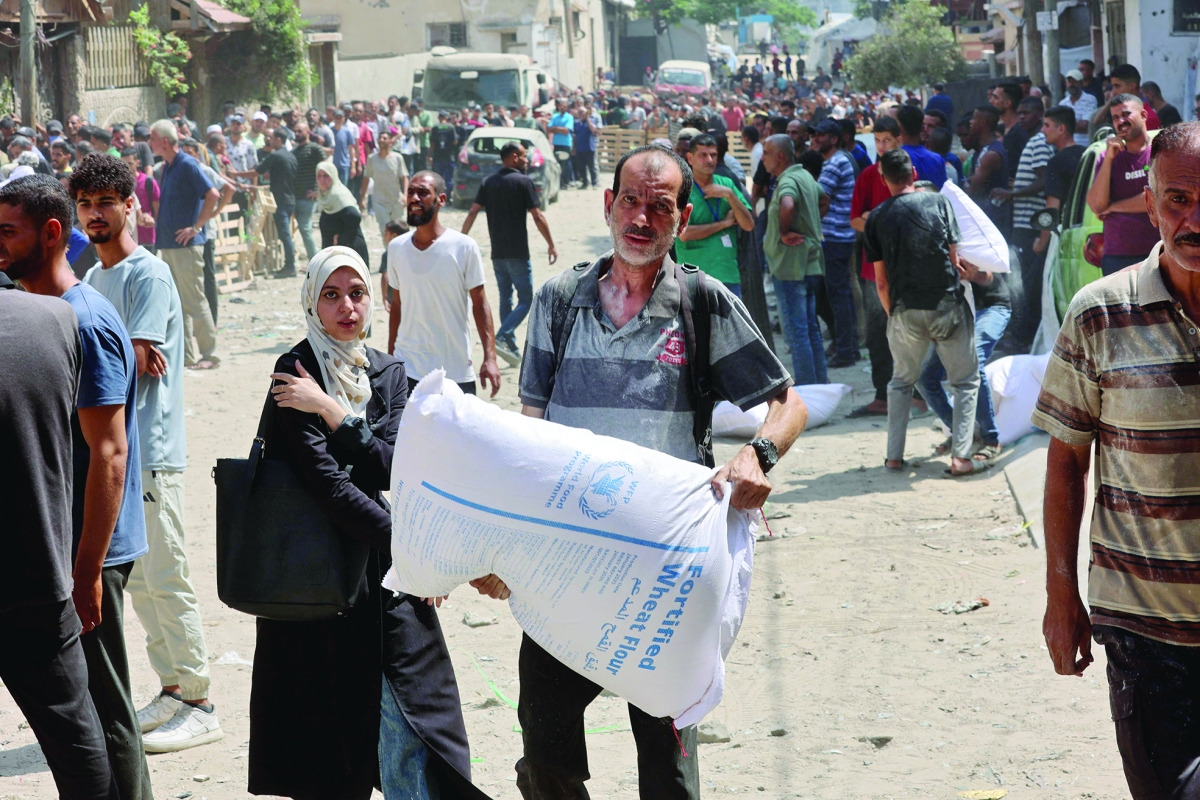 فلسطينيون يحصلون على مساعدات غذائية (أ ف ب)