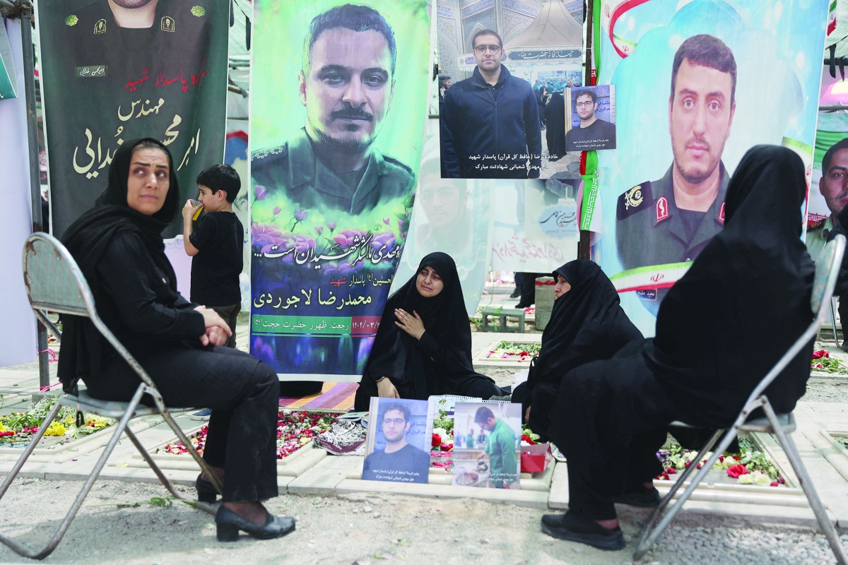 مشيعون عند قبور ضحايا الهجمات الإسرائيلية في مقبرة بهشت زهراء جنوب طهران (رويترز)