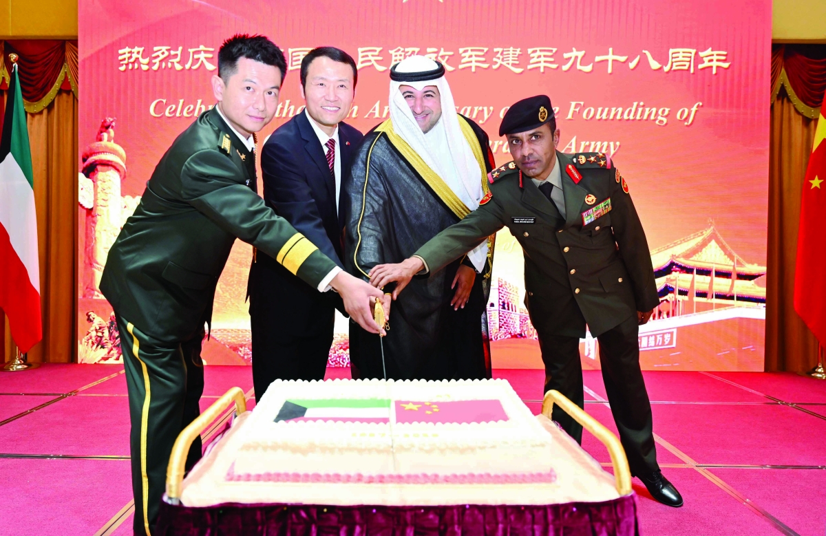 


المشعل والقائم بالأعمال الصيني والملحق الدفاعي يقطعون كعكة الاحتفال	 (تصوير أسعد عبدالله) 