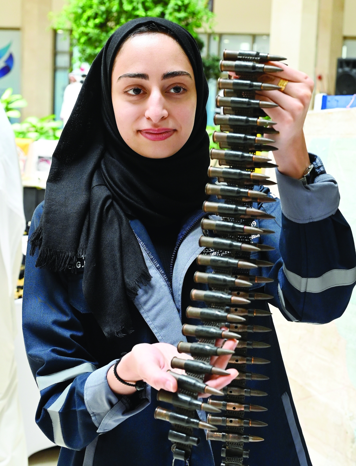 


فتاة تحمل شريط طلقات ضمن المعرض 