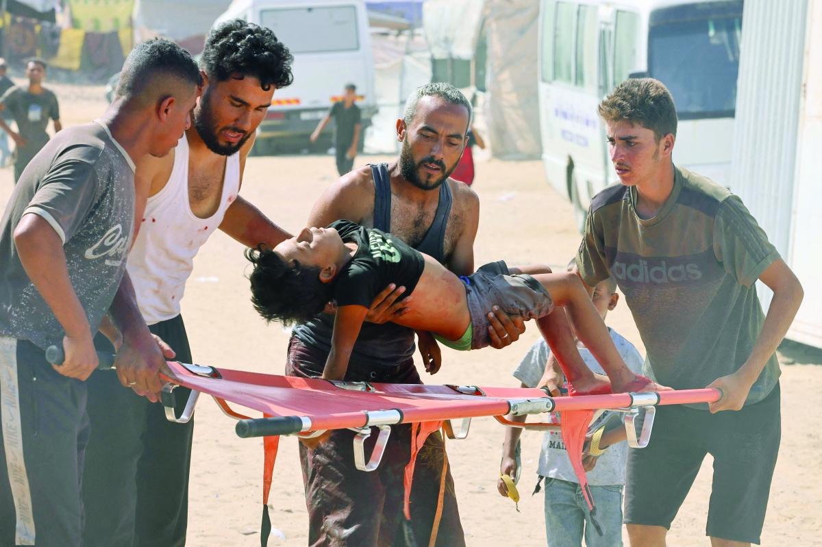 نقل طفل فلسطيني أصيب خلال تلقي مساعدات إلى مستشفى ميداني في رفح (أ ف ب)