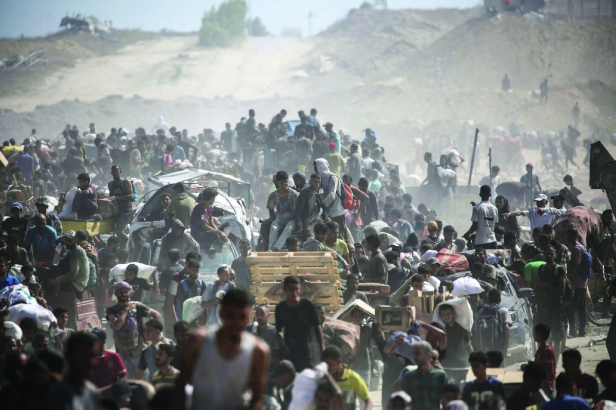 فلسطينيون يحاولون الحصول على مساعدات قرب ممر نتساريم وسط غزة                (رويترز) 