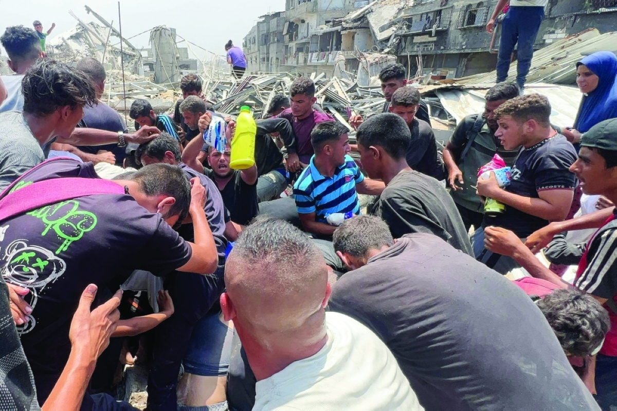 فلسطينيون يتدافعون للحصول على مساعدات غذائية أسقطت جواً فوق مخيم جباليا (أ ف ب) 