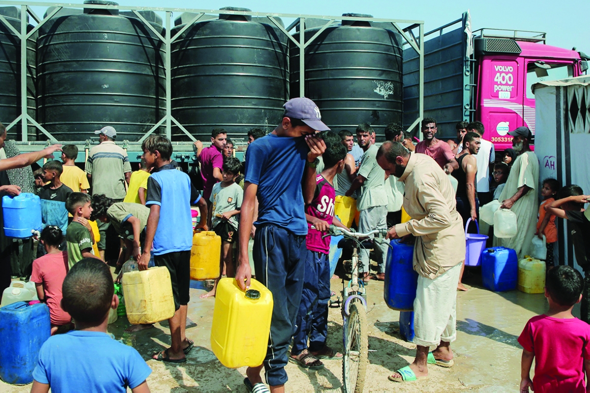 فلسطينيون يتزودون بالمياه في خان يونس (أ ف ب)