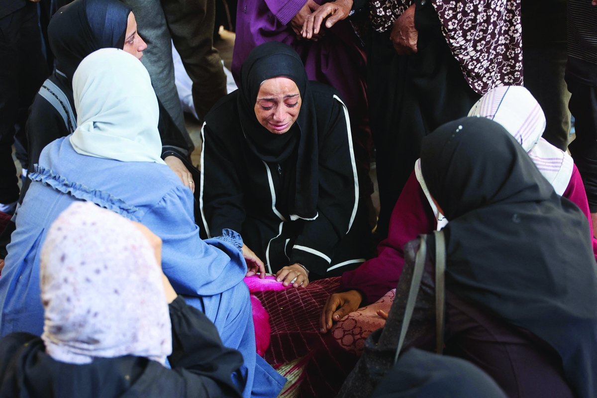 


أسرة فلسطينية فقدت أحد أقاربها في غارة إسرائيلية استهدفت غزة 	  (أ ف ب) 