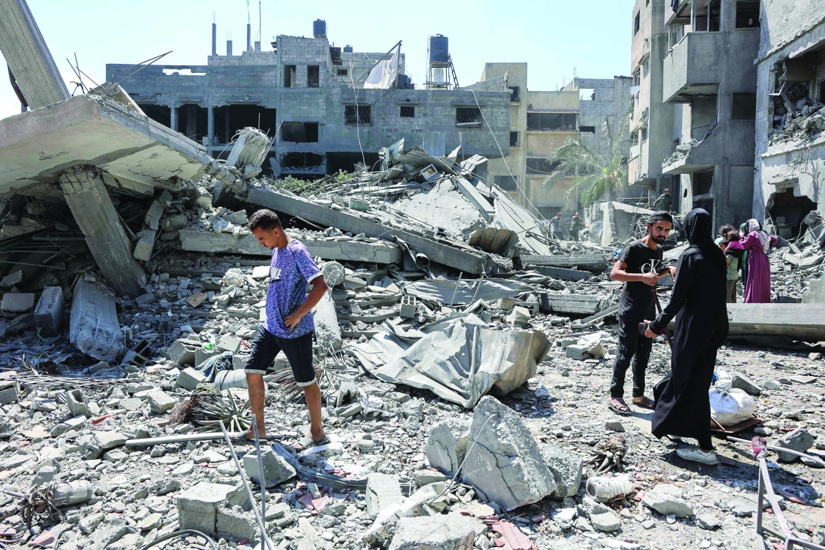 فلسطينيون يتفقدون مسجداً دمرته غارة إسرئيلية في غزة (أ ف ب)